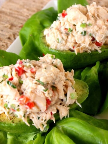 Two Crab Stuffed Avocados on lettuce leaves.