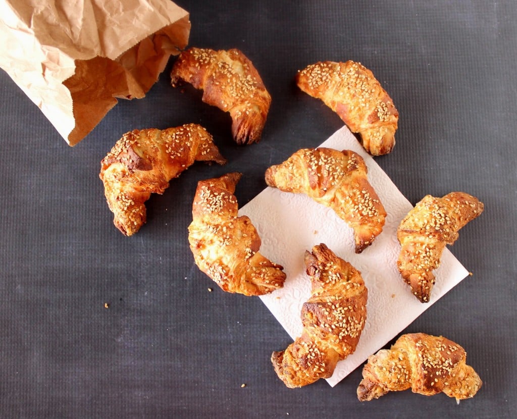 A bunch of Pretzel Croissants spilled out of a brown paper bag.