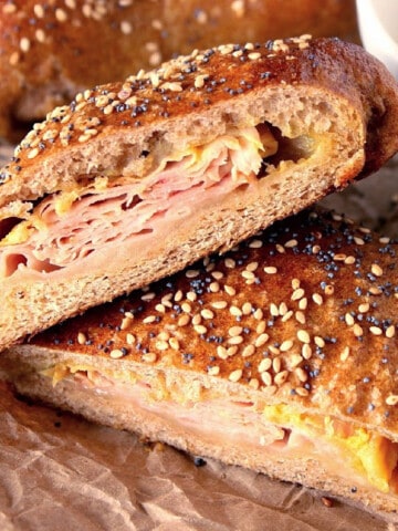 A stuffed Pretzel Pocket with ham and cheese on the inside and sesame and poppy seeds on the outside.