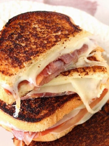 A closeup of a Provolone Grilled Cheese Sandwich with melon and prosciutto.