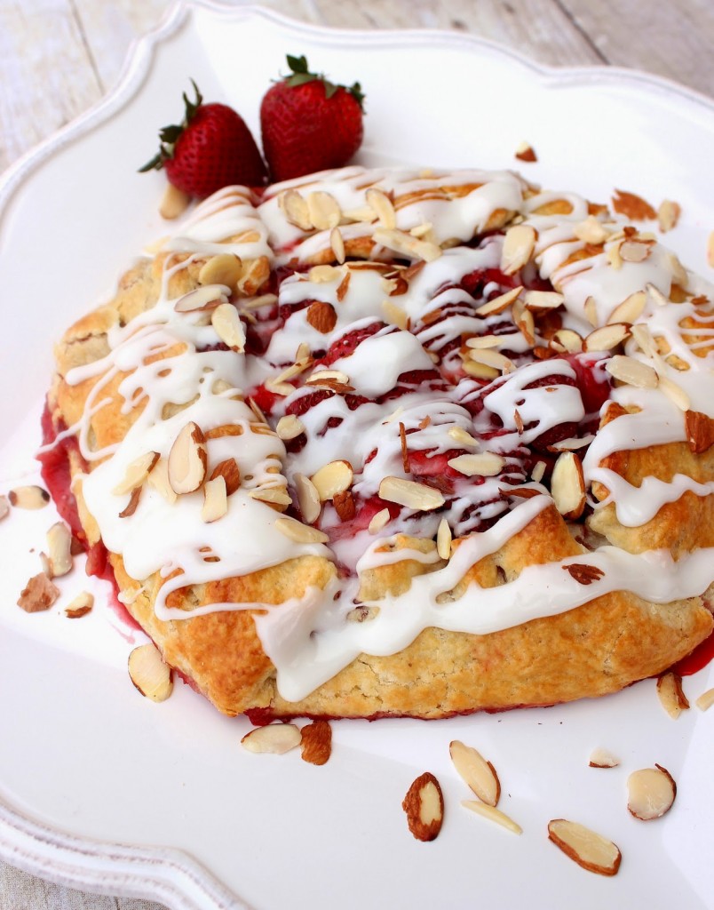 Strawberry Crostata with Sweet Almond Glaze Vertical overhead photo of a strawberry crostata drizzled with almond glaze and covered with slivered almonds