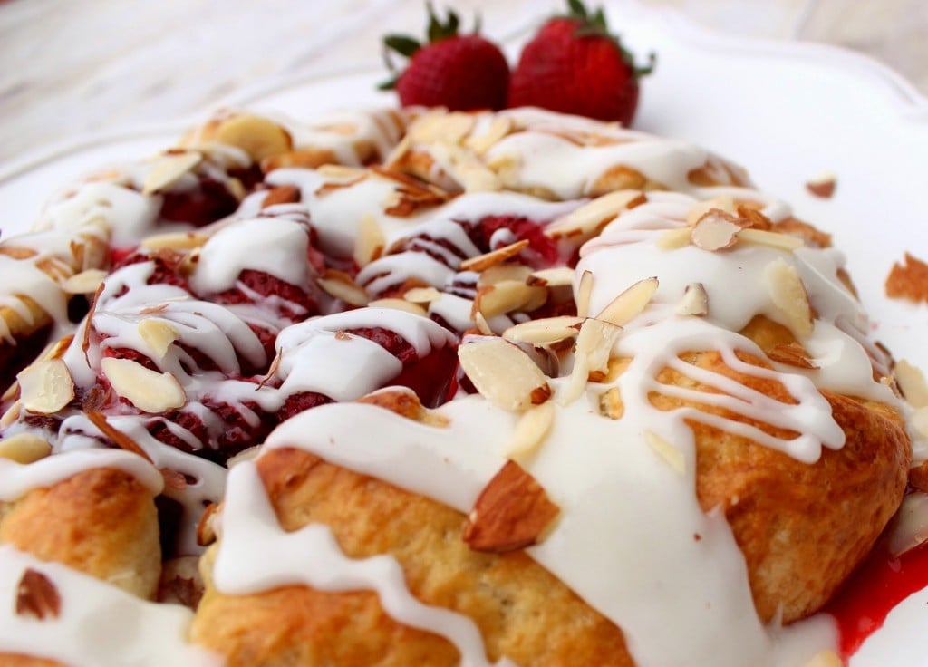 Strawberry Crostata with Sweet Almond Glaze closeup photo of a glazed strawberry crostata with slivered almonds on top