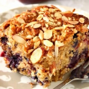 A closeup photo of a square of Almond Oatmeal Coffee Cake with berries.