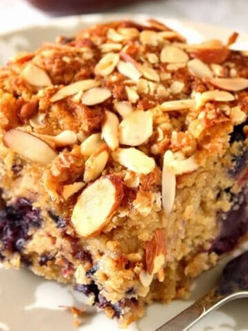A closeup photo of a square of Almond Oatmeal Coffee Cake with berries.