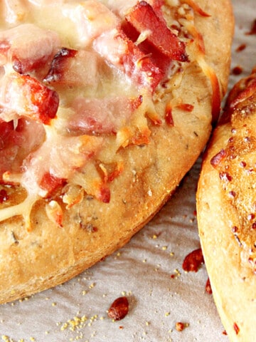 A horizontal closeup photo of two Leek and Onion Focaccia with ham and cheese.