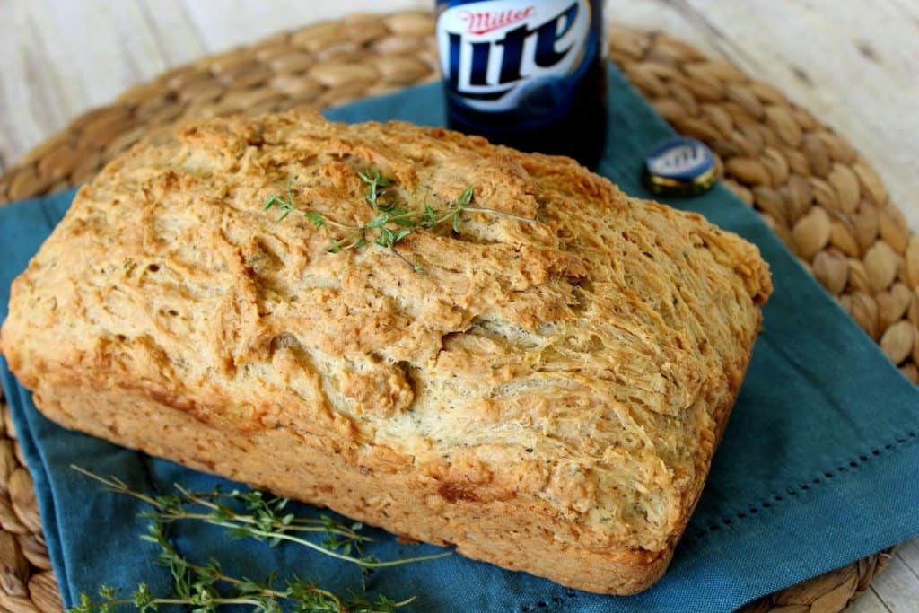Loaf of beer bread with a bottle of beer in the background.