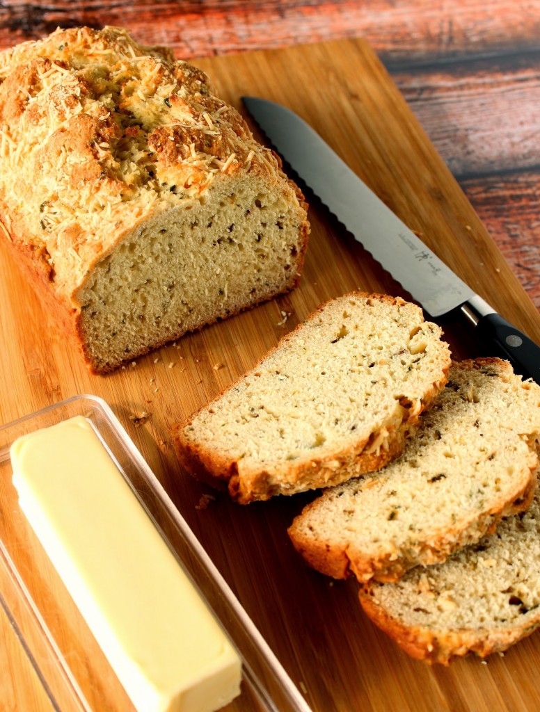 Slices of Homemade Soda Bread on a cutting board with a serrated knife and a stick of butter.