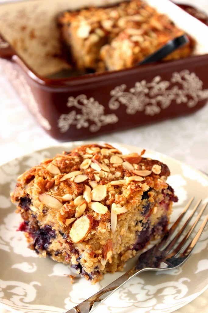 A slice of Berry Almond Oatmeal Coffee Cake on a plate with a fork.