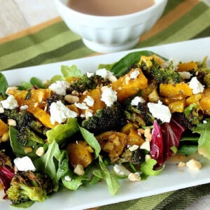 Roasted Golden Beet and Broccoli Salad on a white plate topped with goat cheese.