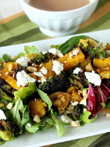 Roasted Golden Beet and Broccoli Salad on a white plate topped with goat cheese.