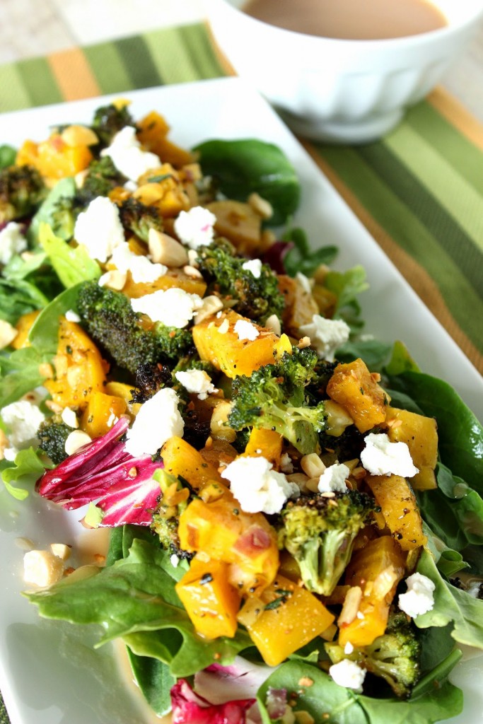 Golden beet and broccoli salad on a long white plate with a green and gold napkin.