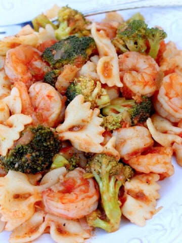 A serving of Shrimp Fra Diavolo on a white plate with broccoli.