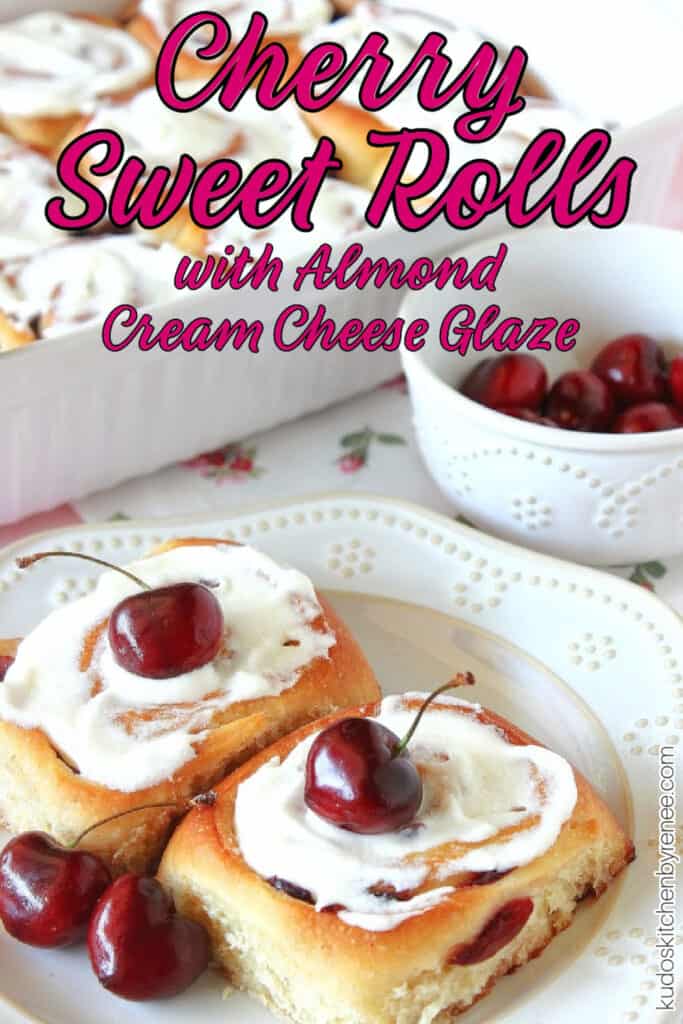 A vertical closeup photo of two Cherry Sweet Rolls on a plate with a small bowl of cherries in the background along with a title text overlay graphic.