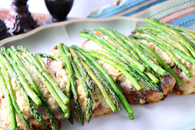 Flour Chicken Oscar on a plate with asparagus spears and crab meat topping