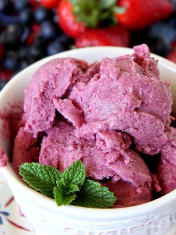 A small bowl of Frozen Greek Yogurt with Fruit in the background.