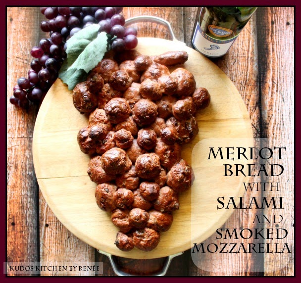 A loaf of Merlot Bread shaped like a bunch of grapes on a round cutting board.