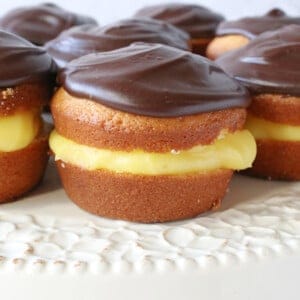 A closeup of a Boston Cream Cupcake topped with chocolate ganache.