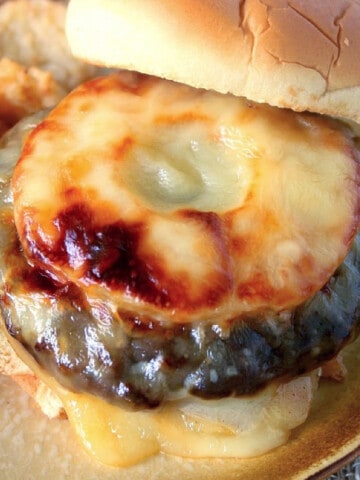 An Aloha Turkey Burger with melted cheese and a pineapple ring on top.