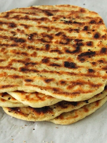 A stack of Grilled Naan Flatbread with grill marks on top