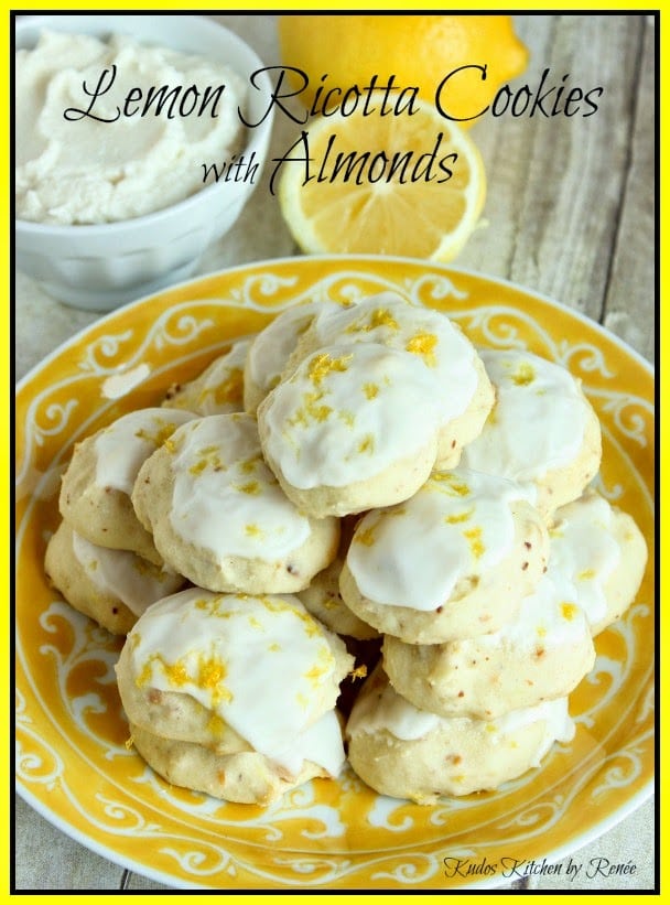 A yellow and white plate stacked with Lemon Ricotta Cookies with white icing.
