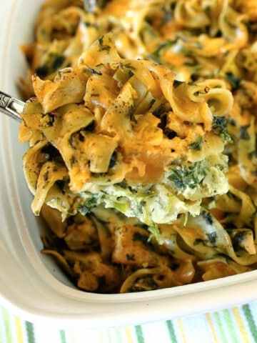 An overhead closeup of a serving spoon filled with Spinach Butternut Squash Casserole.