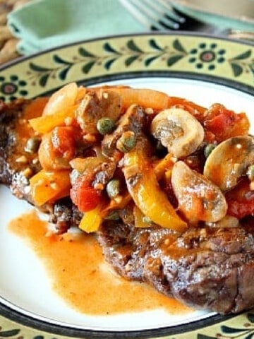 A Steak Pizzaiola on a plate topped with a mushroom sauce