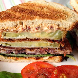 A bacon, lettuce and fried green tomato sandwich on two slices of toast.