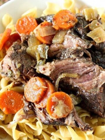 A closeup photo of Slow Cooker Bavarian Pot Roast with carrots and noodles