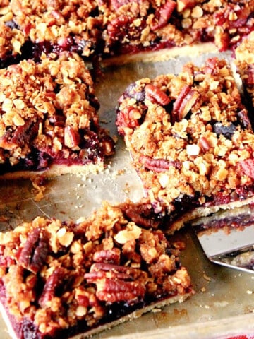 Slices of Blueberry Slab Pie on a baking sheet with a spatula.