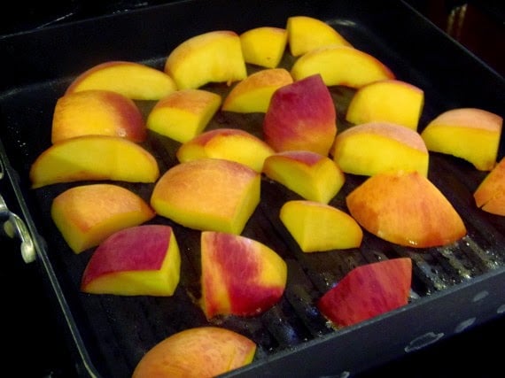 Grilling peach slices in a grill pan.