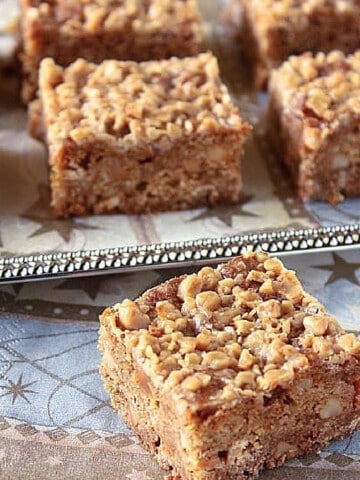 Perfectly cut squares of Oatmeal Macadamia Nut Cookie Bars on a sliver tray.