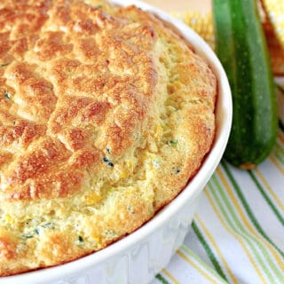 A horizontal offset photo of a Zucchini and Sweet Corn Souffle in a dish on a stripped green and yellow napkin.
