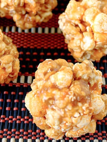 A bunch of Chicago Mix Popcorn Balls on an orange and black placemat.