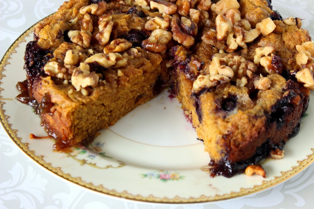 An Slow Cooker Pumpkin Blueberry Cake on a china plate with a slice taken out.