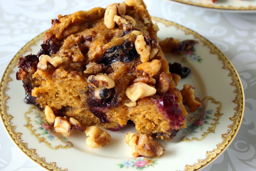 A slice of Slow Cooker Pumpkin Blueberry Cake with walnuts on a pretty china plate.