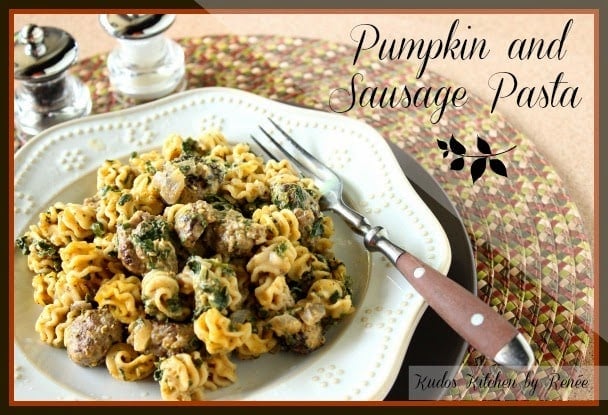 A serving of Pumpkin and Sausage Pasta with spinach and a fork.