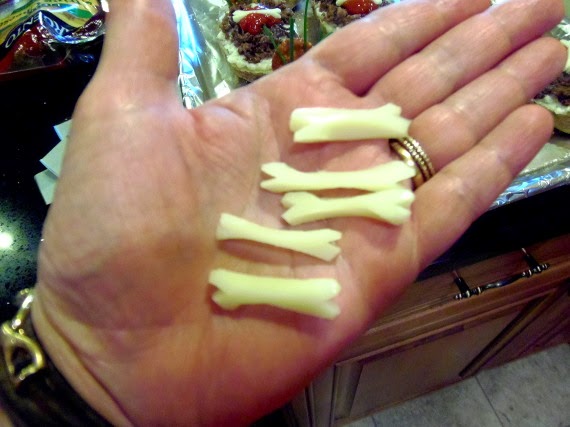 A hand holding string cheese bones.