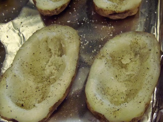 The beginnings of twice baked potatoes with the innards scooped out.