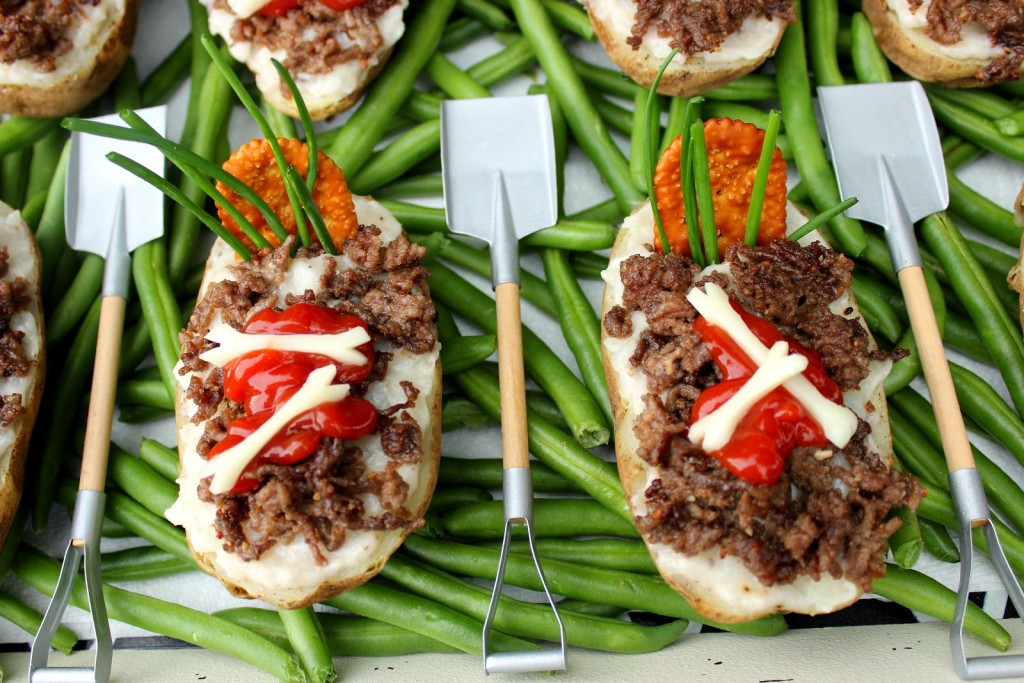 Twice Baked Potato Graves with ground beef dirt, mushroom soup, a cracker tombstone, chive grasses and string cheese bones.