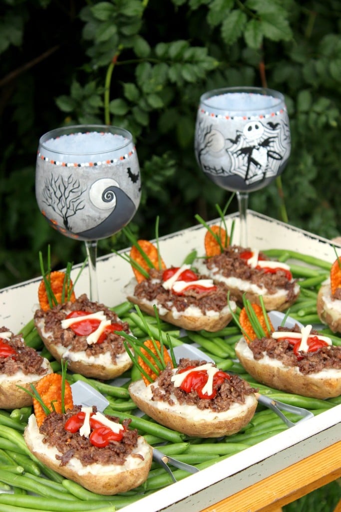 A tray filled with Twice Baked Potato Graves with ground beef, ketchup, string cheese, and green beans for grass.