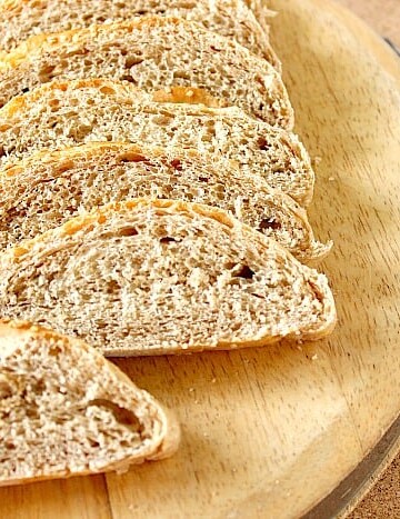 Slices of French bread on a wooden cutting board.