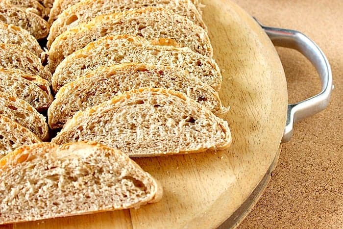 Slices of French bread on a wooden cutting board.