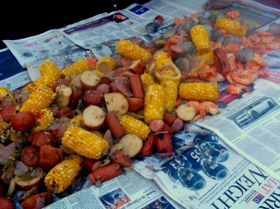 A low country boil seafood and sausage feast spilled out onto a newspaper lined table.