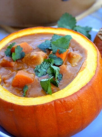 Chicken and Pumpkin Stew served in a mini pumpkin with parsley on top.