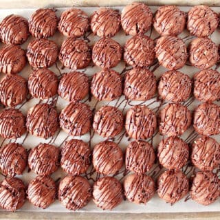 A baking sheet filled with Double Chocolate Creme de Menthe Cookies with a chocolate drizzle over top.