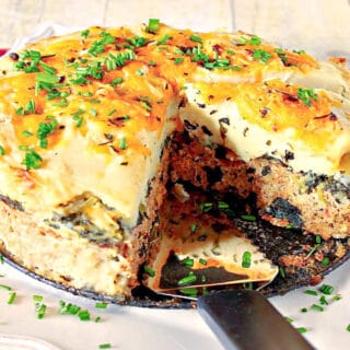 A round Layered Turkey Meatloaf on a square white platter with a serving spatula.