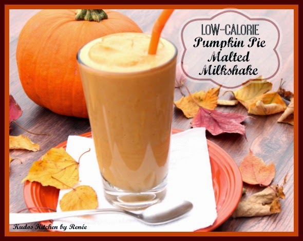 Low-Calorie Pumpkin Pie Malted Milkshake A tall glass filled with a Low Calorie Pumpkin Pie Milkshake and an orange straw and autumn leaves in the background.