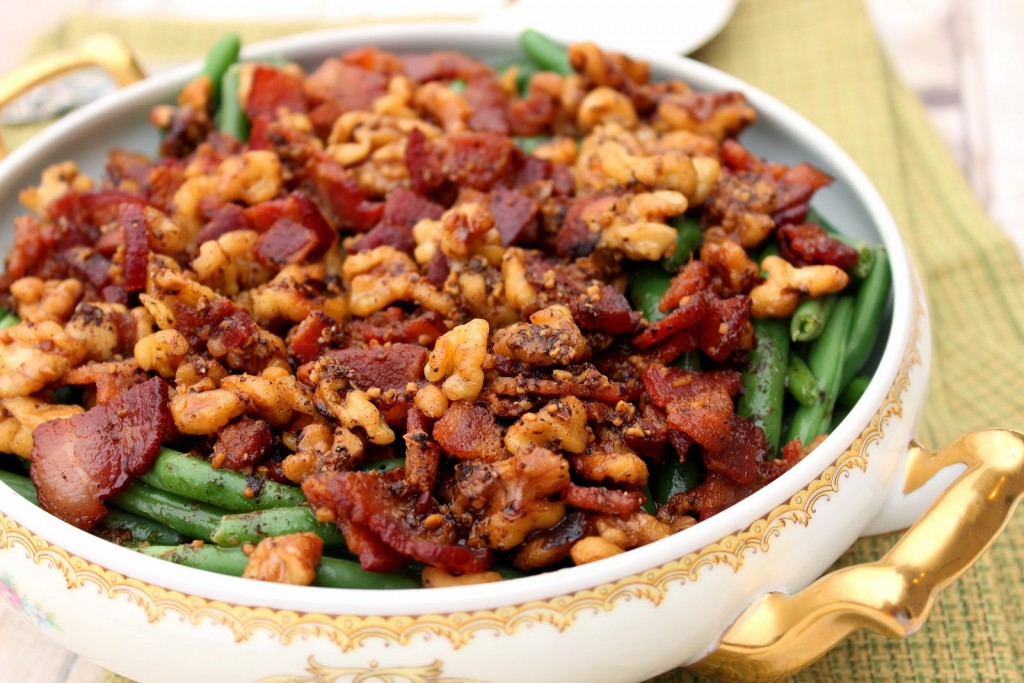 A decorative bowl of green beans covered with bacon and walnuts. Popular Thanksgiving side dish recipe roundup.
