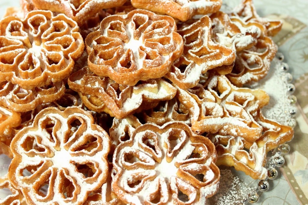 Part of the fun of eating a Rosette Snowflake Cookie is the dusting of confectioners sugar that will snow down the front of your shirt as you crunch into these crispy little holiday treats. There's no way around it so just give in and let it snow! - kudoskitchenbyrenee.com Fried Snowflake Rosette Cookies with Confectioners Sugar Dusting - kudoskitchenbyrenee.com