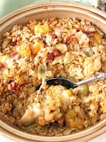 A round casserole dish filled with Baked Farro Casserole with Brussels sprouts and bacon.
